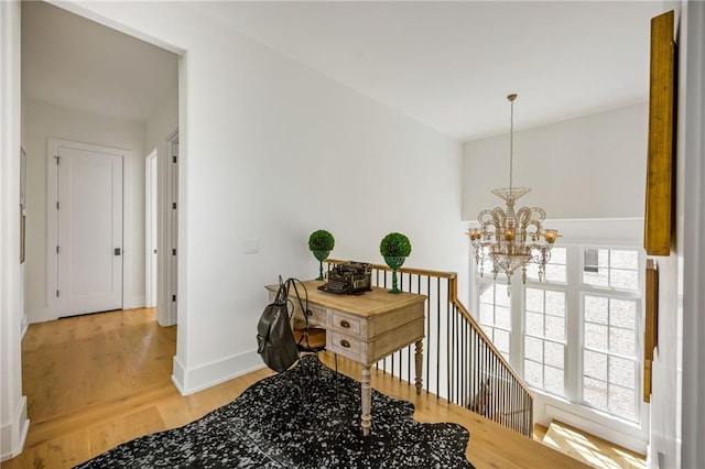 11277 Serenbe Ln, Chattahoochee Hills, GA 30268 - hall featuring a chandelier, light wood-type flooring, baseboards, and an upstairs landing