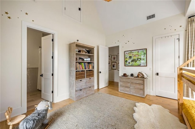 11277 Serenbe Ln, Chattahoochee Hills, GA 30268 - bedroom with light wood finished floors, high vaulted ceiling, attic access, and baseboards