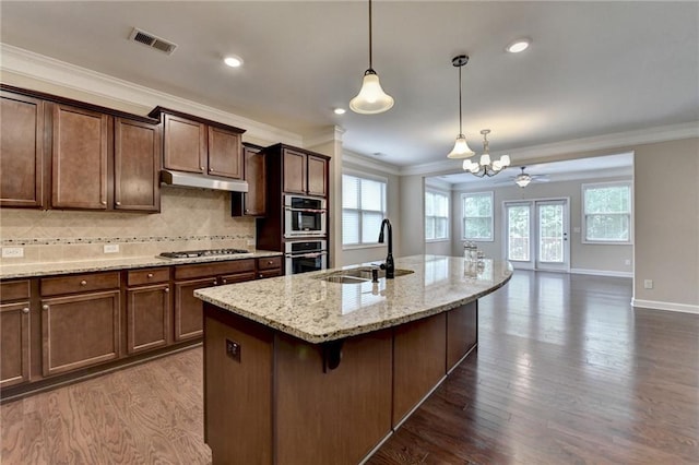 kitchen with visible vents, a sink, appliances with stainless steel finishes, and ornamental molding