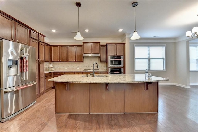 kitchen with crown molding, a sink, stainless steel appliances, tasteful backsplash, and under cabinet range hood