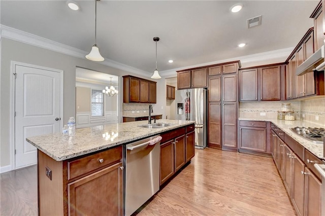 kitchen featuring visible vents, ornamental molding, a sink, light wood finished floors, and appliances with stainless steel finishes