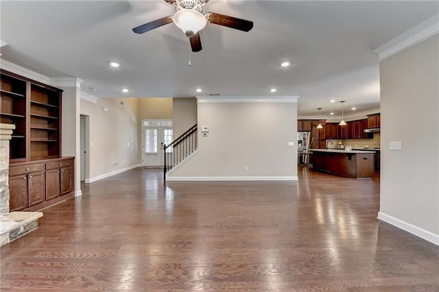 unfurnished living room with recessed lighting, ornamental molding, and baseboards