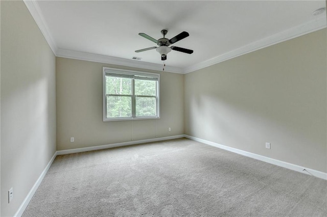 carpeted empty room with baseboards, ornamental molding, a ceiling fan, and visible vents
