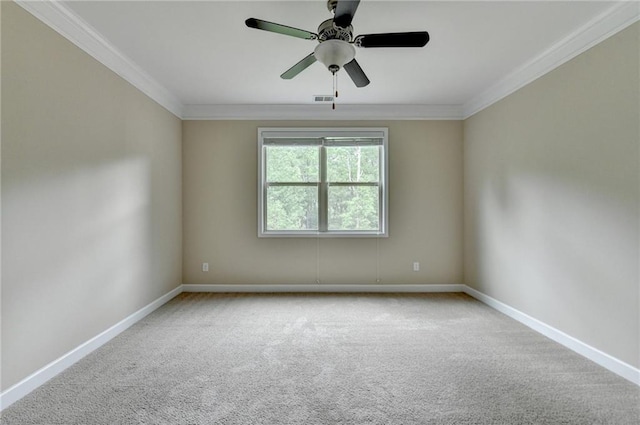 carpeted spare room featuring baseboards, ornamental molding, ceiling fan, and visible vents