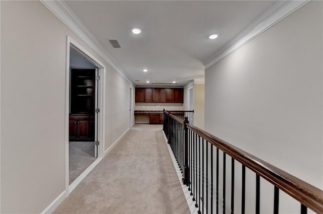 hall featuring visible vents, baseboards, ornamental molding, light carpet, and recessed lighting
