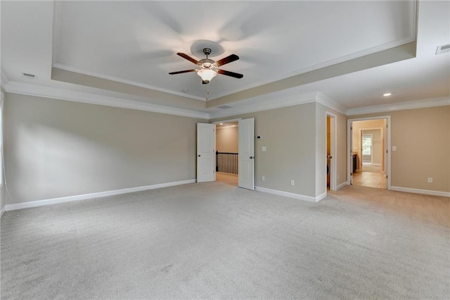 unfurnished bedroom with crown molding, a raised ceiling, and light colored carpet