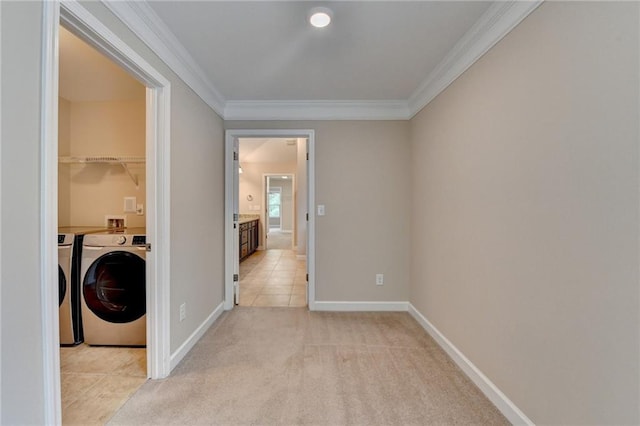 hall featuring independent washer and dryer, baseboards, light colored carpet, and ornamental molding