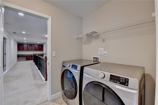 laundry room with independent washer and dryer, laundry area, light carpet, and baseboards
