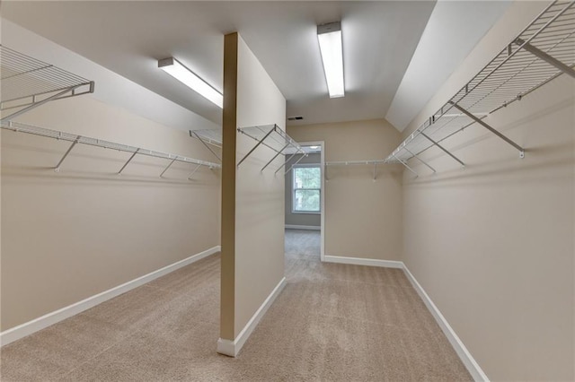 spacious closet featuring carpet flooring and lofted ceiling