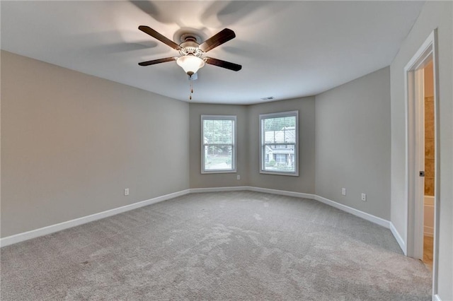 carpeted empty room with baseboards, ceiling fan, and visible vents
