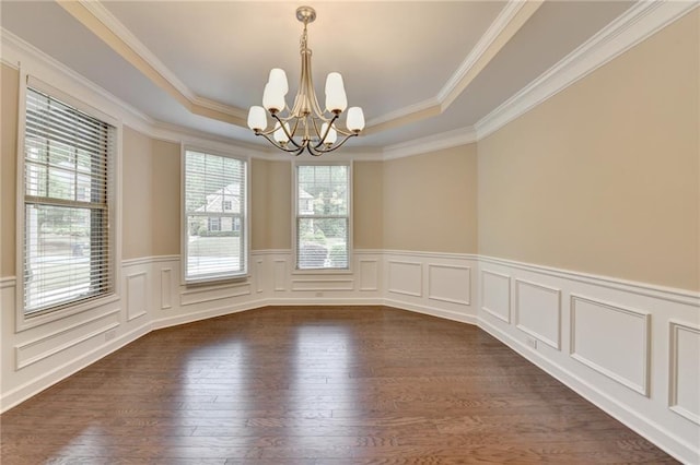 unfurnished room with crown molding, wainscoting, a raised ceiling, dark wood finished floors, and a notable chandelier