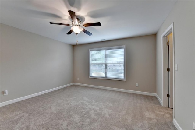 empty room featuring baseboards, a ceiling fan, and light colored carpet