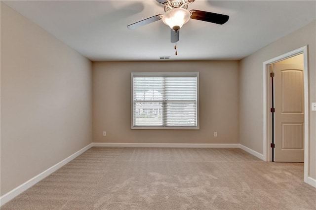 unfurnished room with visible vents, a ceiling fan, baseboards, and light colored carpet