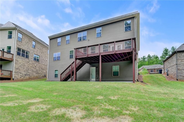 back of property featuring a lawn, a deck, and stairway