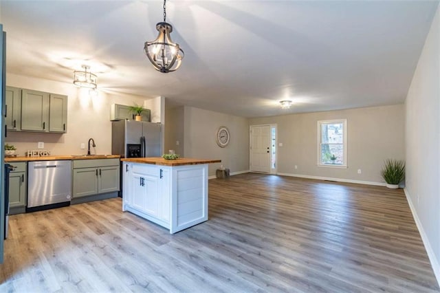 9 Woodberry Dr SE, Silver Creek, GA 30173 - kitchen featuring butcher block counters, stainless steel appliances, a chandelier, baseboards, and light wood-type flooring