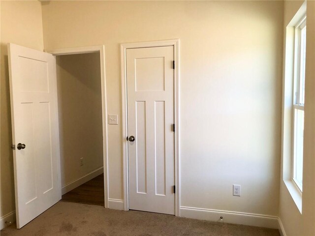 half bathroom featuring baseboards, vanity, toilet, and wood finished floors