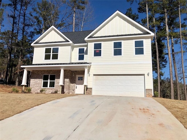 view of front of home featuring board and batten siding, brick siding, driveway, and an attached garage