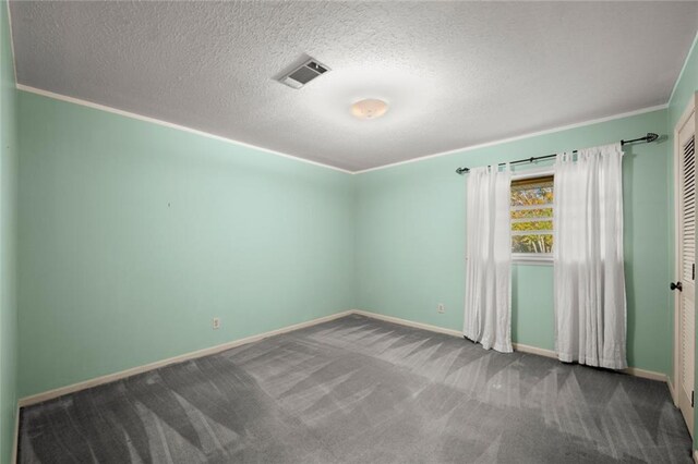 empty room with ornamental molding, carpet floors, and a textured ceiling