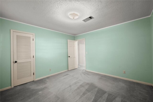 unfurnished bedroom featuring a textured ceiling, carpet flooring, and crown molding