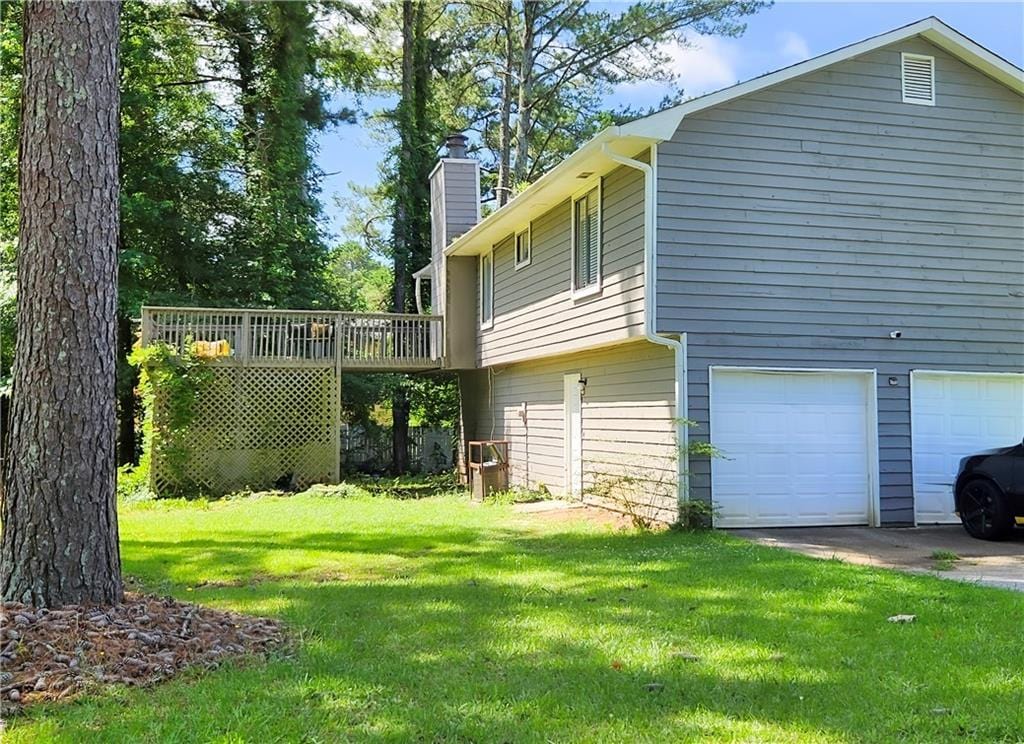 9218 River Chase Way, Jonesboro, GA 30238 - view of home's exterior featuring an attached garage, a chimney, a lawn, and a deck