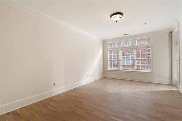 spare room with ornamental molding and hardwood / wood-style floors