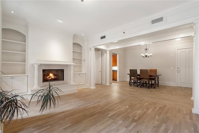 living room featuring ornamental molding, built in features, light hardwood / wood-style floors, and ornate columns