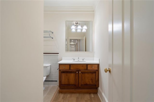 bathroom with hardwood / wood-style flooring, crown molding, vanity, and toilet