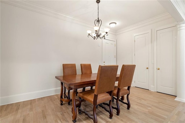 dining room featuring crown molding, ornate columns, light hardwood / wood-style flooring, and a notable chandelier