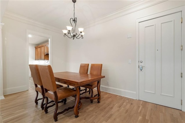 dining area with crown molding, a notable chandelier, and light hardwood / wood-style floors