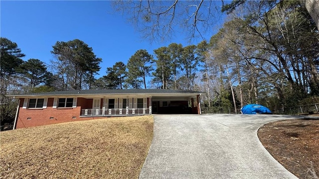 ranch-style home featuring covered porch, brick siding, driveway, crawl space, and a carport