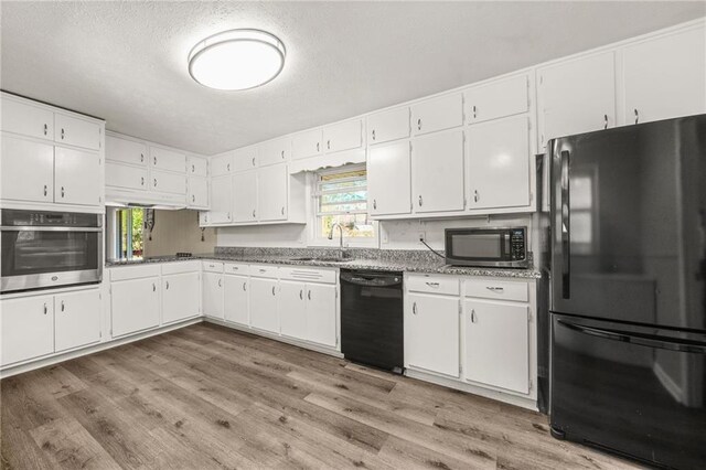 4218 Hideaway Dr, Tucker, GA 30084 - kitchen with white cabinets, a sink, light wood-style floors, and black appliances