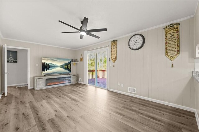 4218 Hideaway Dr, Tucker, GA 30084 - unfurnished living room with visible vents, crown molding, wood finished floors, and a glass covered fireplace
