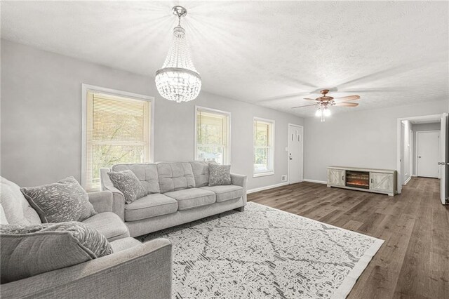 4218 Hideaway Dr, Tucker, GA 30084 - living area with ceiling fan with notable chandelier, a textured ceiling, baseboards, and wood finished floors