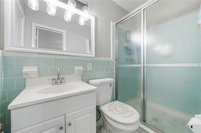 4218 Hideaway Dr, Tucker, GA 30084 - full bath with vanity, tile walls, toilet, a stall shower, and wainscoting