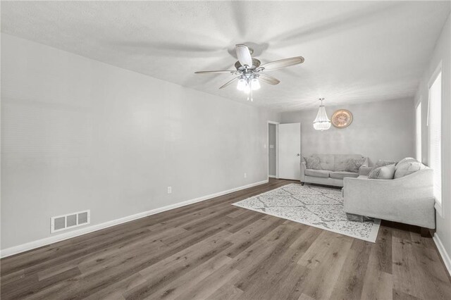 4218 Hideaway Dr, Tucker, GA 30084 - unfurnished living room with baseboards, visible vents, wood finished floors, and ceiling fan with notable chandelier