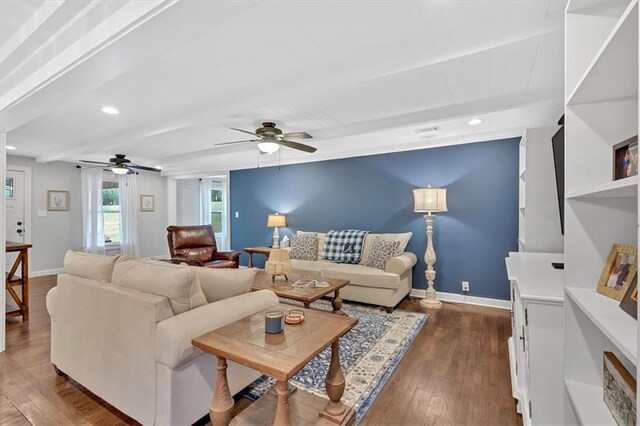 living room with ceiling fan, dark hardwood / wood-style floors, and beam ceiling