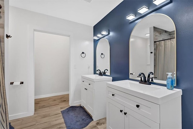 bathroom with hardwood / wood-style flooring, vanity, and curtained shower