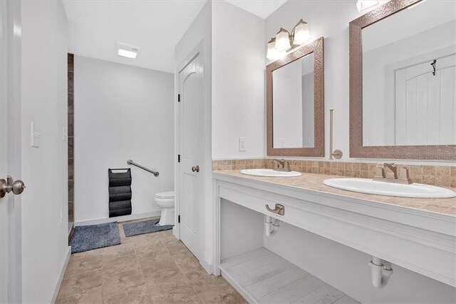 bathroom with vanity, toilet, and tasteful backsplash