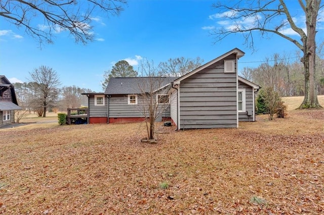 back of property with a deck and a yard