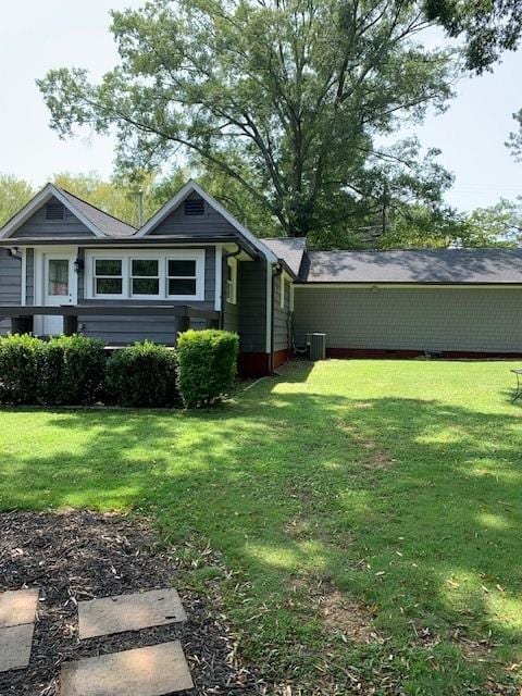 exterior space featuring a front yard and cooling unit