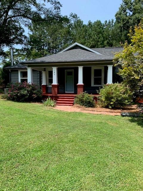 view of front facade featuring covered porch and a front lawn