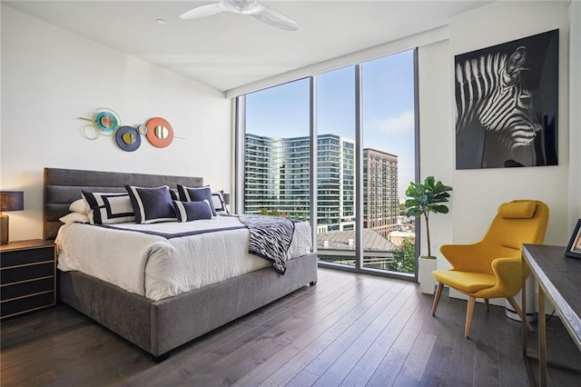 bedroom with multiple windows, dark hardwood / wood-style floors, access to outside, and a wall of windows