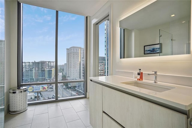 bathroom with expansive windows, tile patterned floors, and sink