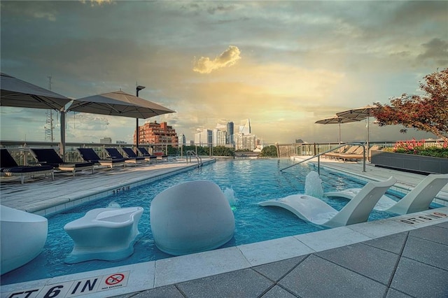 pool at dusk with a patio area