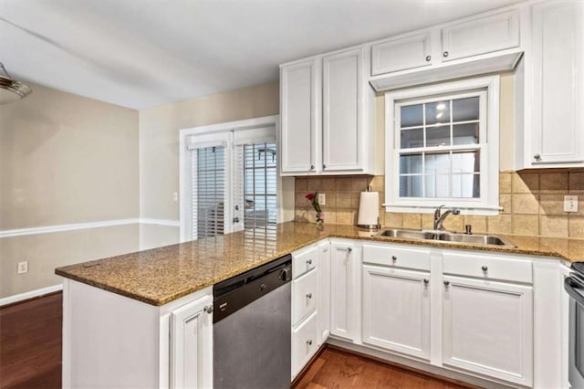 kitchen featuring stainless steel dishwasher, a peninsula, a sink, dark wood-style flooring, and white cabinets