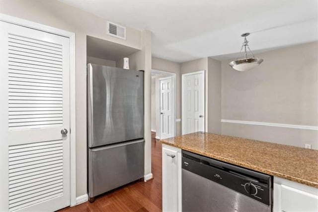 kitchen featuring appliances with stainless steel finishes, dark wood-style floors, white cabinets, pendant lighting, and baseboards