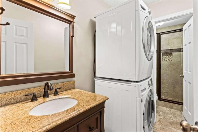 bathroom with stacked washer / drying machine, vanity, and a shower stall