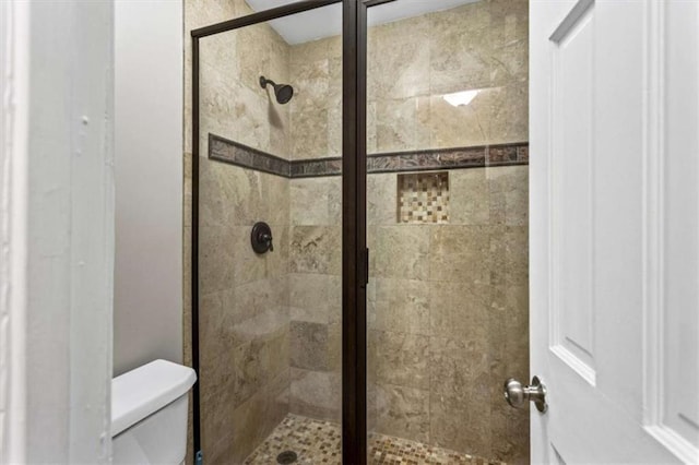 full bathroom with a shower stall and toilet