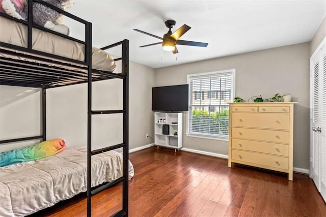 bedroom with baseboards, hardwood / wood-style floors, and a ceiling fan