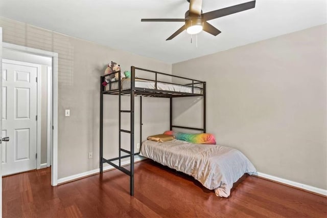 bedroom featuring baseboards, wood finished floors, and ceiling fan